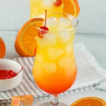 Tequila sunrise with orange and cherry in it