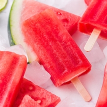red popsicle on top of ice and a slice of watermelon