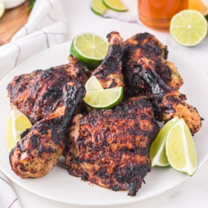 grilled chicken wings and thighs with limes around them